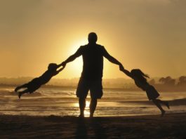 Un père jouant avec ses enfants à la plage