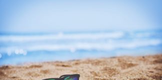 Des lunettes de soleil sur du sable à la plage