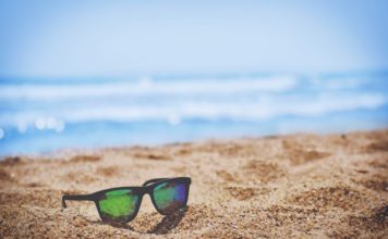 Des lunettes de soleil sur du sable à la plage