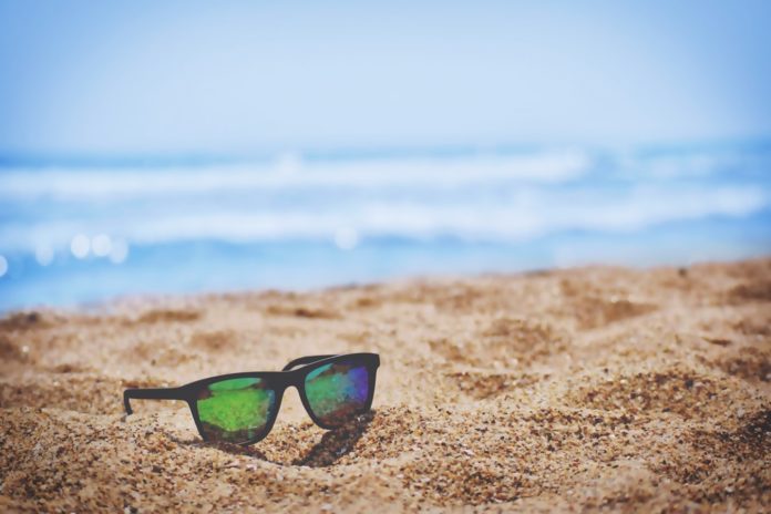 Des lunettes de soleil sur du sable à la plage