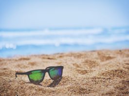 Des lunettes sur le sable d'une plage en été.