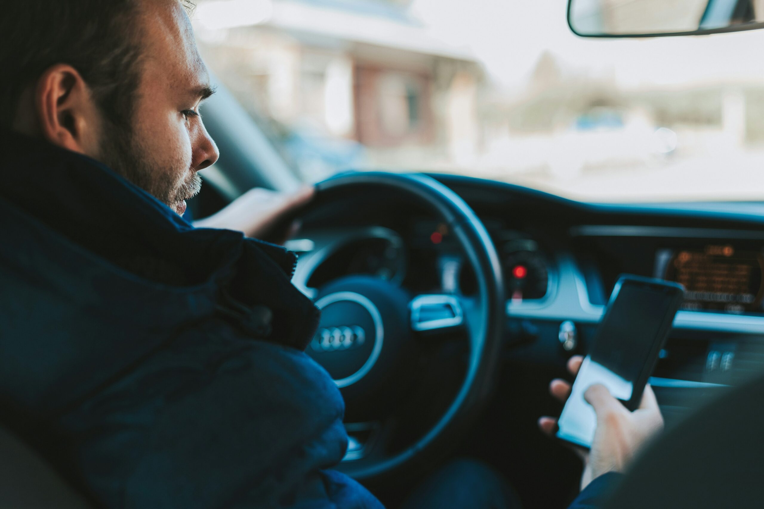 Un homme avec le téléphone au volant.